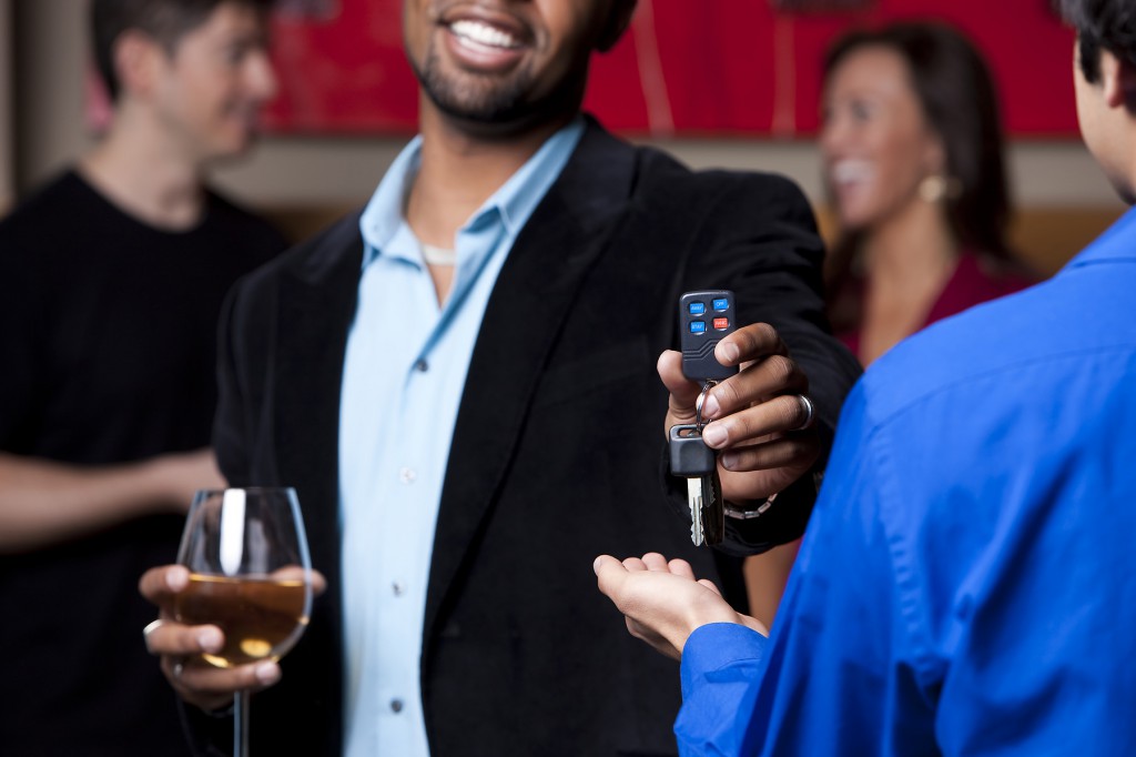 gentleman drinking wine and handing his keys over to not drive